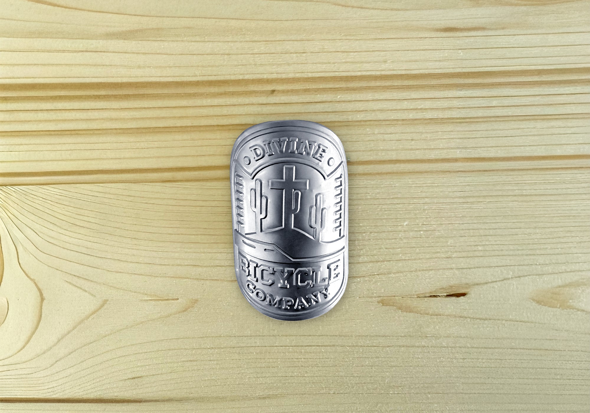 Divine BMX head badge featuring a cross focal point with Arizona desert background, cactus, and Divine Bike Company text.