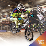 Corben Sharrah racing in the vet pro class at the 2025 Grands on the Divine BMX race bike, taking the lead through the first turn with two riders close behind on his left.