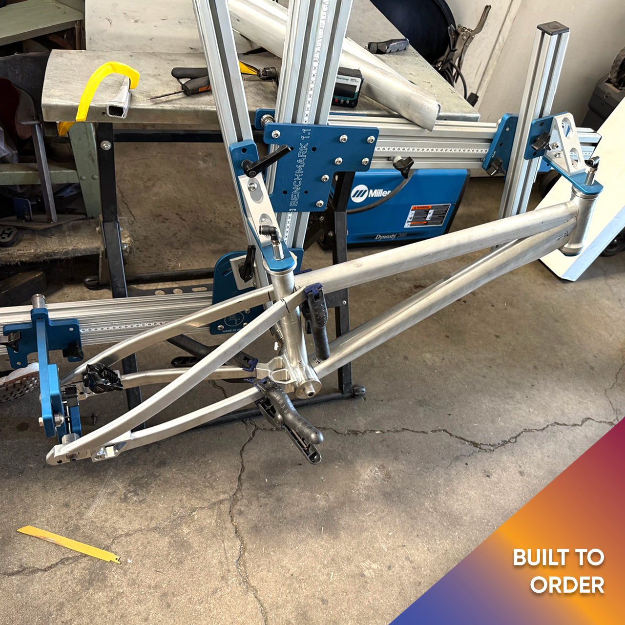 Another angle of Divine BMX bike being assembled in a jig, showcasing precision build process.