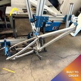 Another angle of Divine BMX bike being assembled in a jig, showcasing precision build process.