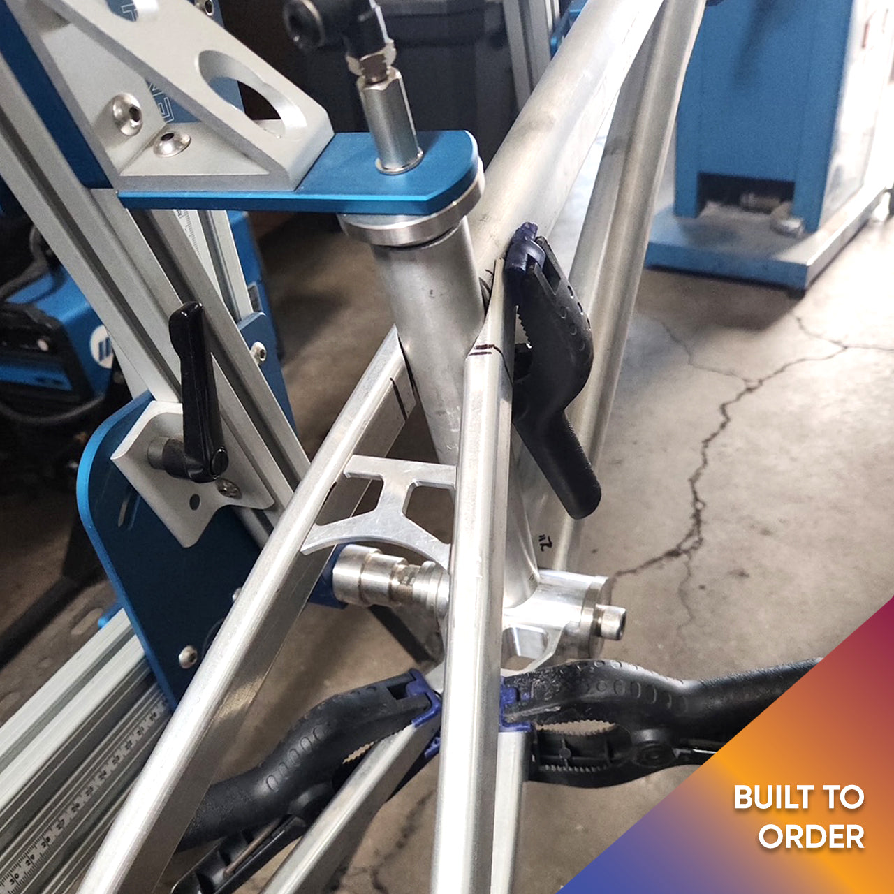 Divine BMX bike being assembled in a jig, showcasing precision build process.