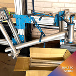 Another angle of Divine BMX bike being assembled in a jig, showcasing precision build process.