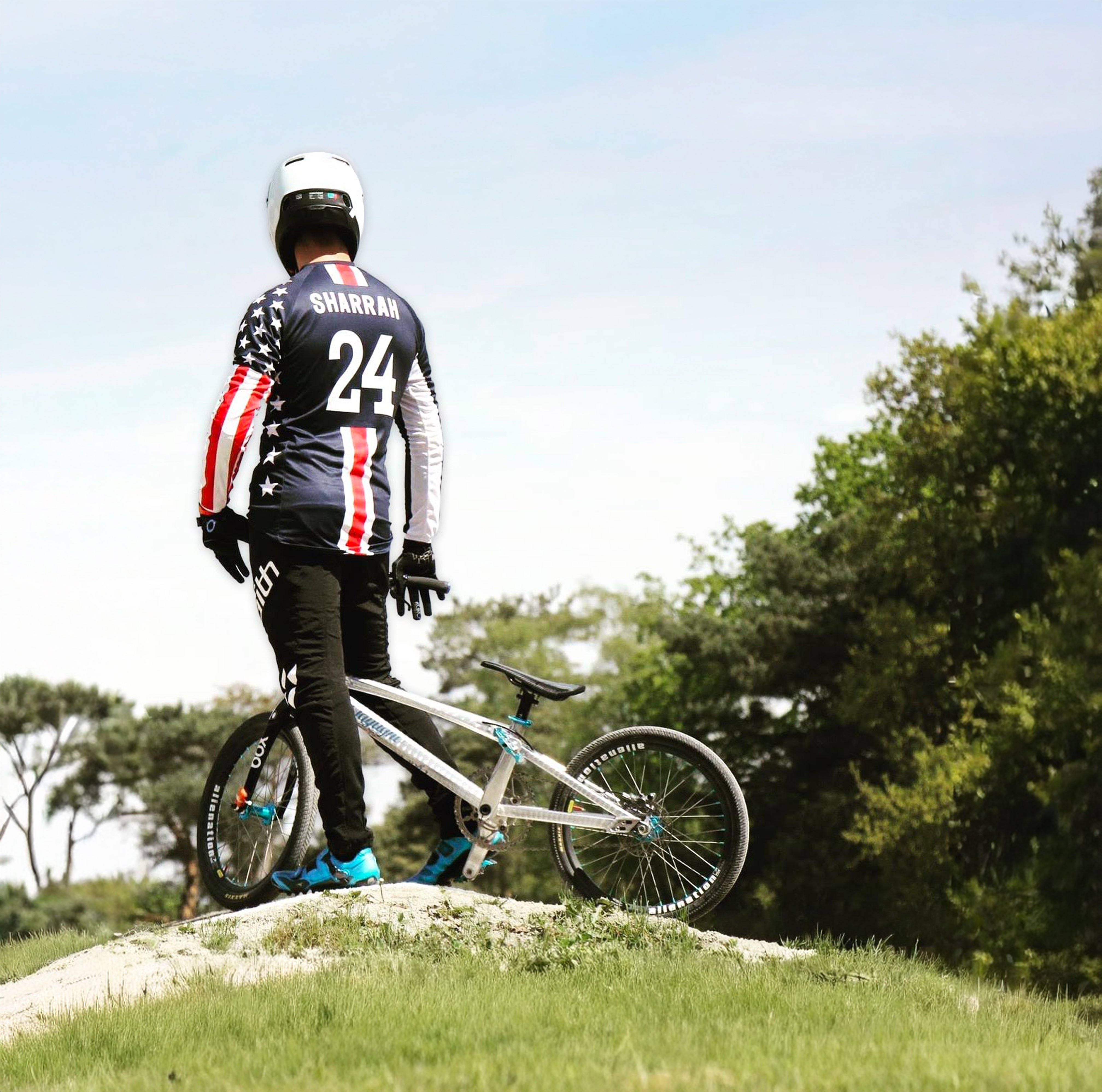 Corben Sharrah in his USA Team jersey, perched on a BMX jump, preparing for the track.